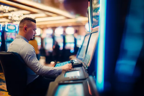 A young woman relaxing with her phone while dynamic casino elements float around her, illustrating the smooth mobile experience offered by the JLMMM app.